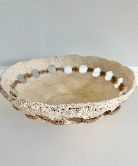A beige, primitive handmade paper mache bowl with jute string accents on the side, placed on a flat surface. Designed by Artist Tam M Olson.