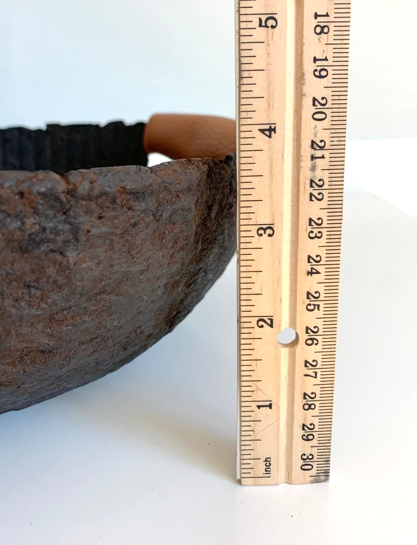 Close up of a rustic black paper mache bowl with leather handles, displaying a natural aged appearance and leather snap handles. Measures about 3.75 inches tall. Hand crafted by Artist Tam M Olson.