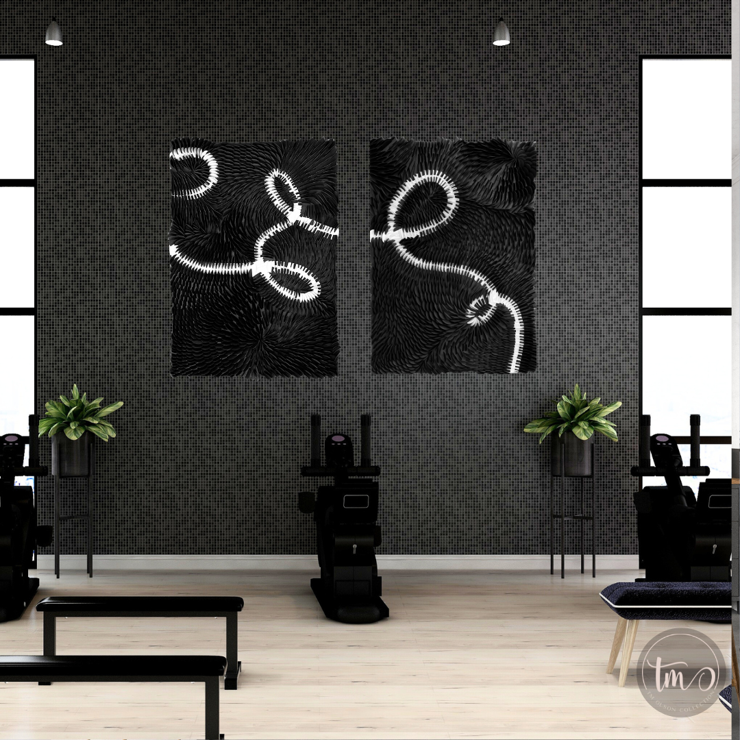 Two abstract, black and white, dimensional and textured wall art pieces on a wall in a corporate gym space. Original Art by Tam M Olson