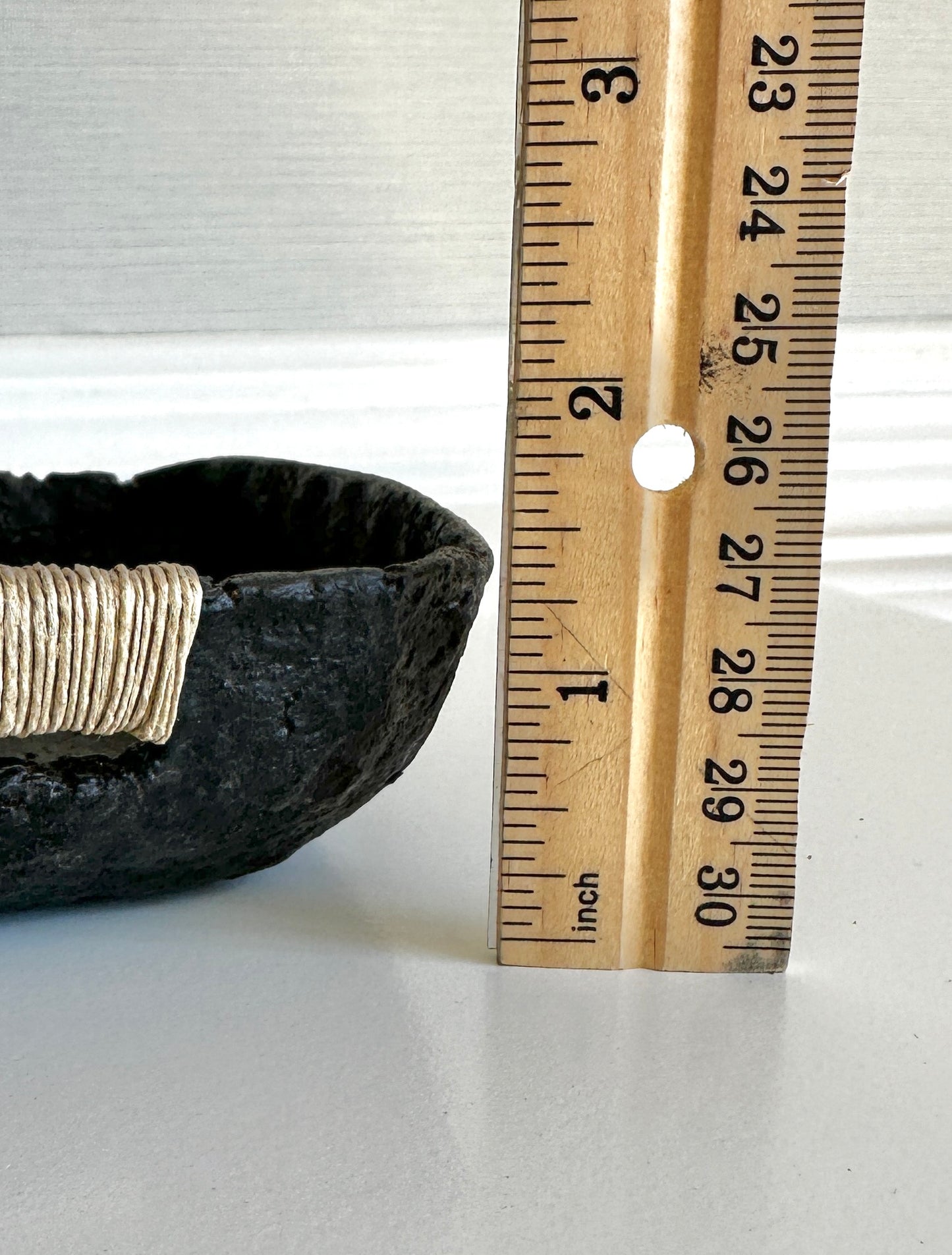 Close up of a small black decorative tray with a textured surface, made from paper mache, with jute string detail. Height 1.5 inches. Original art by artist Tam M Olson