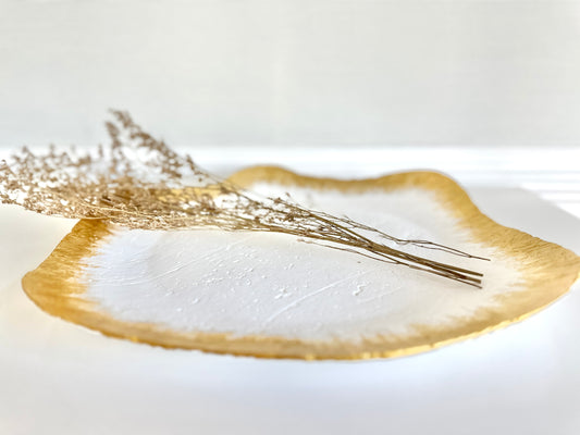 A wavy, matte white and gold paper mache tray with a shiny gold rim, featuring a handcrafted design. By artist Tam M Olson