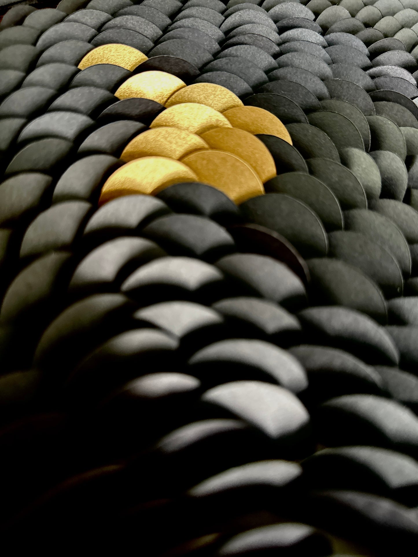 Textured black surface with gold accents. Part of an original abstract wall sculpture by artist Tam M Olson