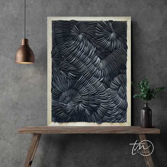 Framed abstract art piece on a wooden console table against a gray wall. Original black textured wall art by artist Tam M Olson.