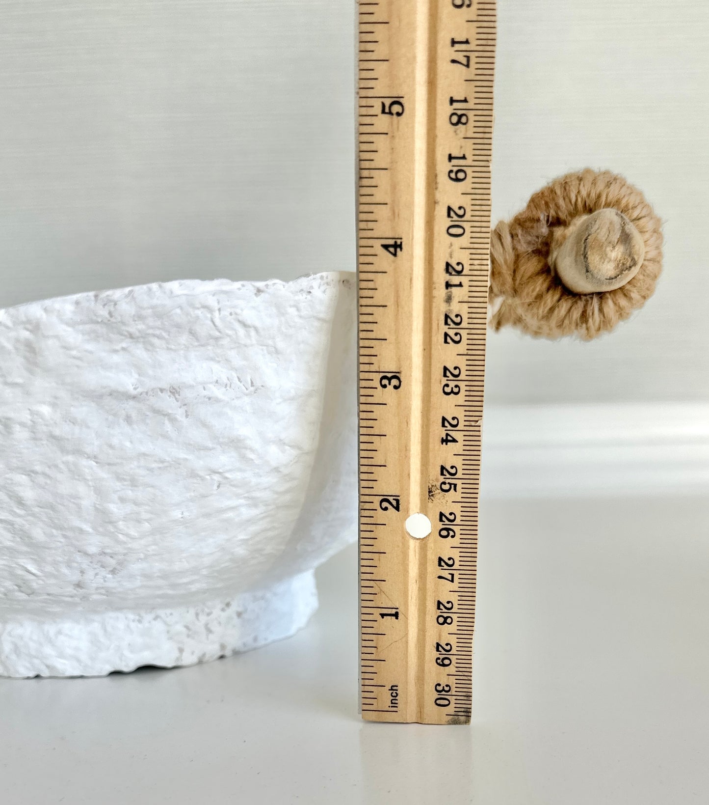 close up view of a handmade white paper mache bowl with driftwood and jute handles displaying height of bowl without handles at 3.75 inches. Designed by Artist Tam M Olson.
