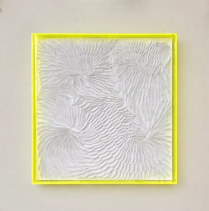 Abstract textured artwork in a neon yellow frame acrylic shadow box on a beige wall by artist Tam M Olson