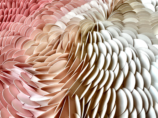 Close up of textured wall art featuring shades of pink, nudes, beiges and white.