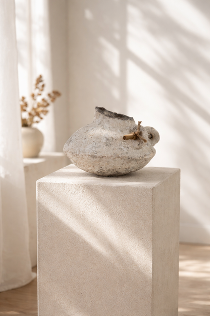 Textured handmade vase on a pedestal with soft lighting. Original design by artist Tam M Olson
