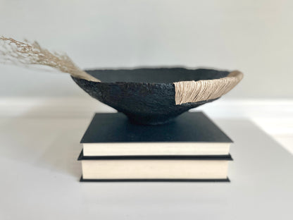 Decorative Black Bowl with Jute Twine and Wide Disposition on top of a small stack of books. Hand Made Paper Mache Bowl by Artist Tam M Olson.