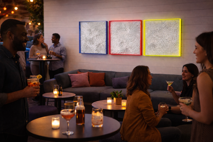 People socializing in a cozy bar with drinks and beautiful unique colorful wall art by Artist Tam M Olson