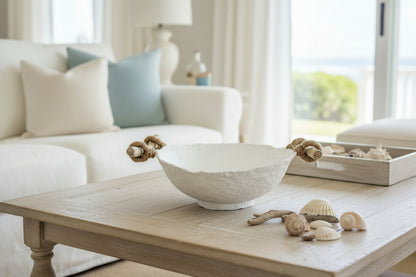 White textured decorative bowl with drift wood handles wrapped in jute rope sitting on coffee table in a coastal living room next to sea shells. Original handmade bowl by artist Tam M Olson.
