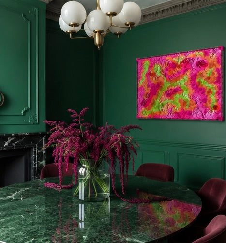 Dining room with green walls, marble table, and colorful abstract dimensional textured art. Original art by artist Tam M Olson
